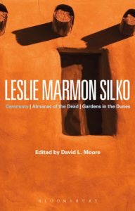 Book cover image for Leslie Marmon Silko, edited by David L. Moore.  Orange-toned image of adobe structure. 